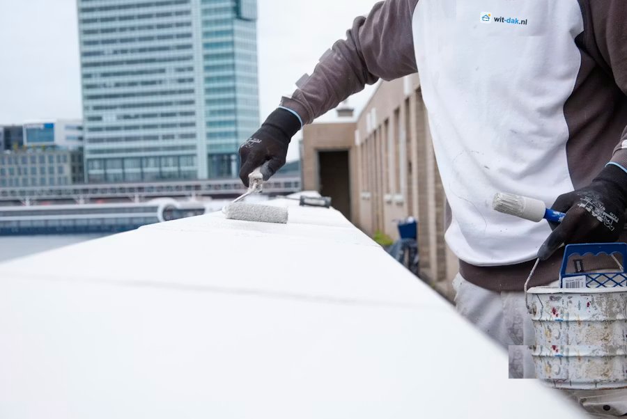 Vakman van Wit-dak.nl brengt witte reflecterende coating aan met een roller